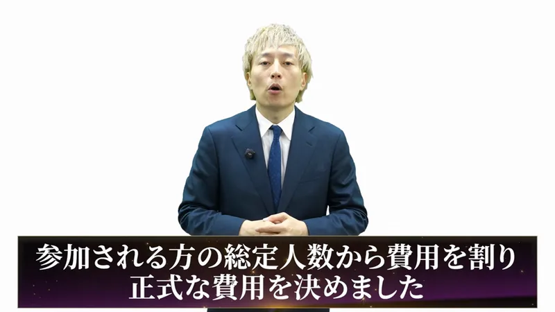 中井耀志の動画の場面。スーツの男性の下に、参加される方の総定人数から費用を割り正式な費用を決めましたという字幕が出ている